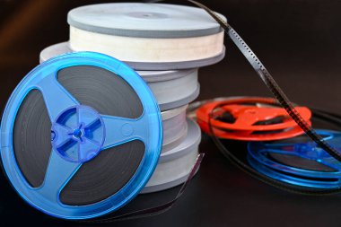 Siyah bir arka planda, eski filmlerin makaraları, kutular şeklinde katlanmış ve sadece masanın üzerinde uzanmış, rahat bir aile çemberinde sessiz bir akşamda izlenmeye hazır.