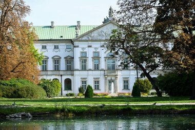 1688-1699 yılları arasında inşa edilmiş antik bir şatonun yakınında, küçük bir gölet ve çiçek açan bir çiçeklikle çevrili güzel bir parkta güneşli bir sonbahar günü..