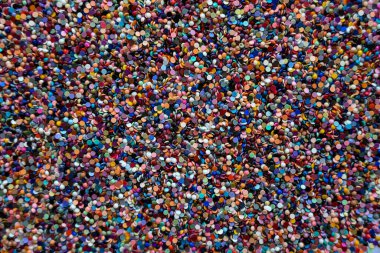 Aynı boyutta çok sayıda boncuğun düz bir yüzeyde yattığı parlak, çok renkli bir arka plan. Olası konsept: Duvar kağıdı, arkaplan, kapak.