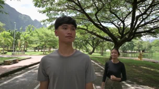 Asian Pretty Girl Teasing Handsome Boy While Walking Public Park — Stock Video