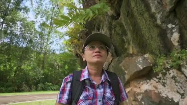 身穿休闲装 头戴数码石碑的地质学家女性探索着公园里石灰岩山形成的巨大岩石 — 图库视频影像