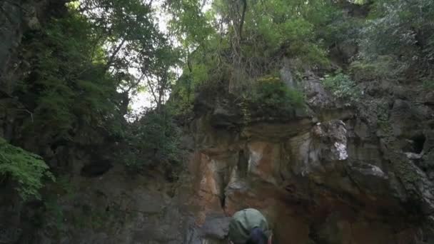 Solo Žena Dobrodruh Kráčí Jeskyně Pod Strmými Útesy Které Pokrývají — Stock video