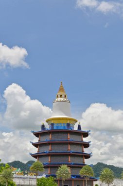 Dikey fotoğraf, Budist tapınağında bulutlu mavi gökyüzü olan muhteşem bir Çin tarzı pagoda. Wat Mahathat Wachiramongkhon ya da Wat Bang Thong, Krabi Eyaleti, Tayland.