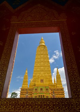 Budist tapınağında mavi gökyüzü olan göz kamaştırıcı altın pagoda. Pencereden çekilen fotoğraf. Wat Mahathat Wachiramongkhon ya da Wat Bang Thong, Krabi Eyaleti, Tayland. 