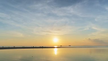 Koh Samui 'de gün batımında bulutlu mavi gökyüzü ile deniz manzarası. Sular çekildiğinde sahilde yürüyen siluetlerle hızlı çekim görüntüleri..