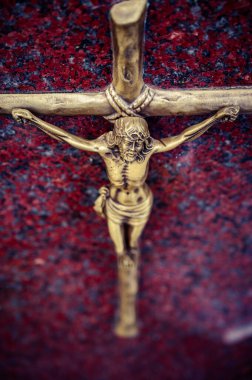 Golden Crucifix on a Red Granite Background clipart