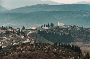 Hilltop Kilisesi ve Cypress Ağaçlı Manzaralı Köy Manzarası