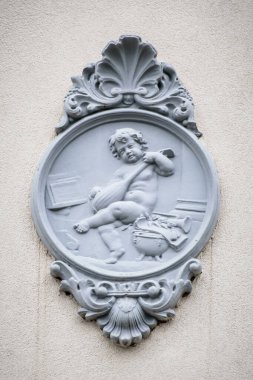 METKOVIC, CROATIA - November 18, 2024: Decorative relief of a cherub with musical instruments on a historic building facade in Metkovic, Croatia clipart