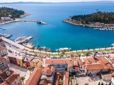 Aerial view of Makarska city center with its vibrant waterfront, yachts, traditional architecture, and the stunning Adriatic Sea coastline clipart