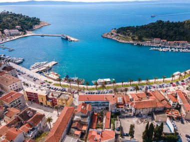 Aerial view of Makarska city center with its vibrant waterfront, yachts, traditional architecture, and the stunning Adriatic Sea coastline clipart