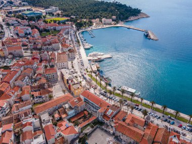 Aerial view of Makarska city center with its vibrant waterfront, yachts, traditional architecture, and the stunning Adriatic Sea coastline clipart