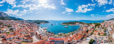 Aerial view of Makarska city center with its vibrant waterfront, yachts, traditional architecture, and the stunning Adriatic Sea coastline clipart