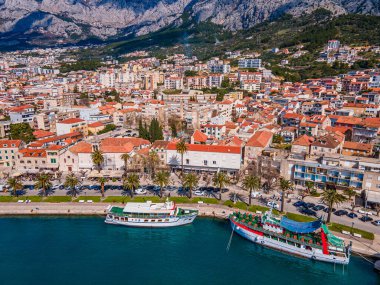 Aerial view of Makarska city center with its vibrant waterfront, yachts, traditional architecture, and the stunning Adriatic Sea coastline clipart