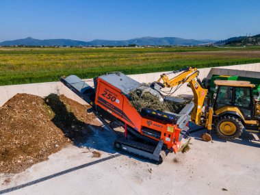 METKOVIC, CROATIA - 15 Nisan 2024: Sürdürülebilir Atık Yönetimi İçin Ağır Makineler ve Kompost Yığınlarıyla Endüstriyel Gübreleme Tesisi