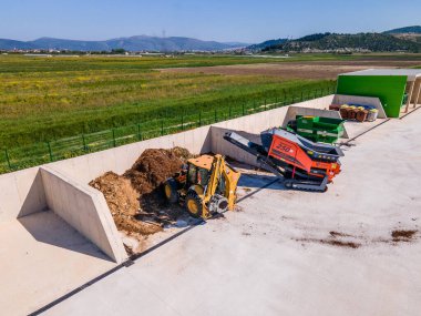 METKOVIC, CROATIA - 15 Nisan 2024: Sürdürülebilir Atık Yönetimi İçin Ağır Makineler ve Kompost Yığınlarıyla Endüstriyel Gübreleme Tesisi