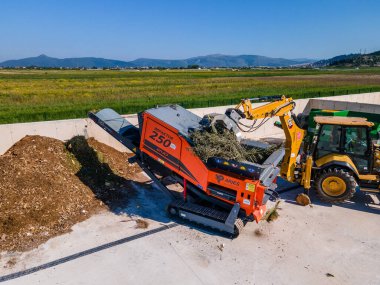 METKOVIC, CROATIA - 15 Nisan 2024: Sürdürülebilir Atık Yönetimi İçin Ağır Makineler ve Kompost Yığınlarıyla Endüstriyel Gübreleme Tesisi