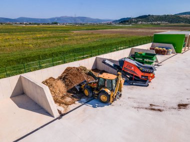 METKOVIC, CROATIA - 15 Nisan 2024: Sürdürülebilir Atık Yönetimi İçin Ağır Makineler ve Kompost Yığınlarıyla Endüstriyel Gübreleme Tesisi