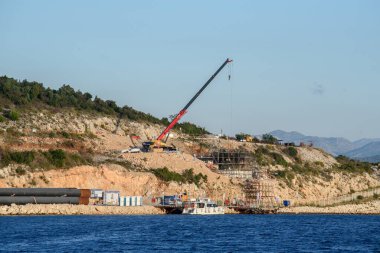 KOMARNA, CROATIA - 9 Ekim 2019: Peljesac Köprüsü İnşaat Alanı Görünür Kırmızı Turna, Büyük Çelik Borular ve Adriyatik Denizi 'ndeki Yanaşma Teknesi
