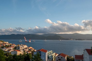 KOMARNA, CROATIA - 9 Ekim 2019: Peljesac Köprüsü şantiyesi, vinci ve Adriyatik Denizi 'ndeki gemileri olan yerleşim köyü Komarna' nın görüntüsü