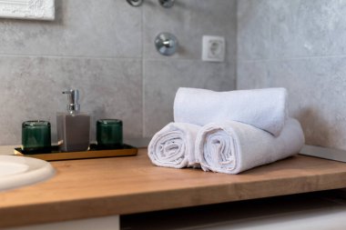 Lüks bir Modern Ev Tasarımı için ahşap tezgahlarda Rolled Havluları ve Şık Aksesuarlarıyla Zarif Banyo Dekoru