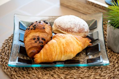 Delicious Breakfast Setting Featuring Fresh Orange Juice, Croissants, and Donut on a Stylish Outdoor Table Arrangement for a Relaxing Start to the Day clipart