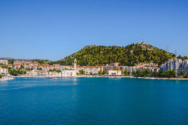 Сценический вид с воздуха на Плоце, Южная Хорватия, Адриатический прибрежный город с потрясающей гаванью, дома на холмах и живую набережную в Далматинском регионе