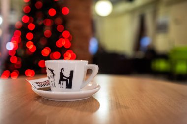 Cozy Coffee Moments with Festive Christmas Lights and Artistic Ceramic Cup. Warm Holiday Vibes in a Modern Caf Setting clipart