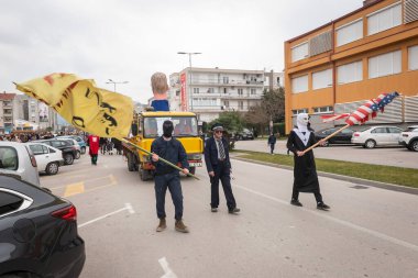 METKOVIC, CROATIA - 19 Şubat 2023: Geleneksel maskeli ve kostümlü karnaval katılımcıları ve festival katılımcıları yıllık maskeli balo sırasında şehir sokaklarında geçit töreni yapıyorlar.