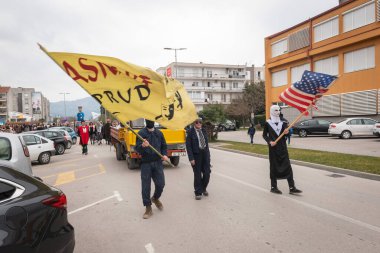 METKOVIC, CROATIA - 19 Şubat 2023: Geleneksel maskeli ve kostümlü karnaval katılımcıları ve festival katılımcıları yıllık maskeli balo sırasında şehir sokaklarında geçit töreni yapıyorlar.