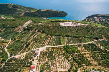 Güney Hırvatistan üzüm bağları ve Kremena ve Komarna yakınlarındaki Adriyatik kıyı şeridi, manzaralı yuvarlanan tepeler, yemyeşil üzüm bağları ve uzakta adaları olan açık mavi deniz