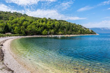 Kristal berraklığında turkuaz suları, kayalık kıyı şeridi, gür Akdeniz yeşilliği ve Hırvatistan 'ın güney Dalmaçya kentinde huzurlu bir plajı ile Adriyatik kıyı şeridi sersemletiyor.