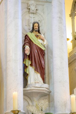 Sacred Heart of Jesus Statue on an Ornate Church Altar Decorated with Candles clipart