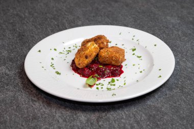 Beyaz tabakta tatlı kızılcık soslu kızarmış Camembert peyniri. Gurme Aperatif Yemekler ve Tatil Menüleri İçin Mükemmel