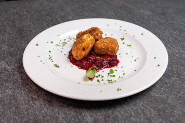 Beyaz tabakta tatlı kızılcık soslu kızarmış Camembert peyniri. Gurme Aperatif Yemekler ve Tatil Menüleri İçin Mükemmel