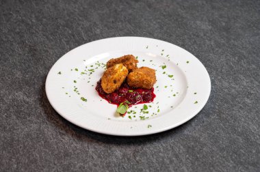 Beyaz tabakta tatlı kızılcık soslu kızarmış Camembert peyniri. Gurme Aperatif Yemekler ve Tatil Menüleri İçin Mükemmel