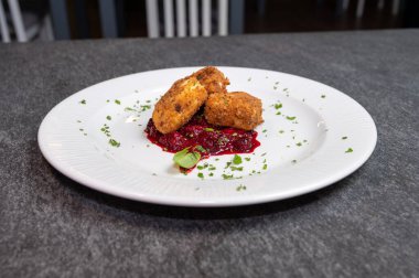 Beyaz tabakta tatlı kızılcık soslu kızarmış Camembert peyniri. Gurme Aperatif Yemekler ve Tatil Menüleri İçin Mükemmel