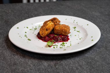 Beyaz tabakta tatlı kızılcık soslu kızarmış Camembert peyniri. Gurme Aperatif Yemekler ve Tatil Menüleri İçin Mükemmel