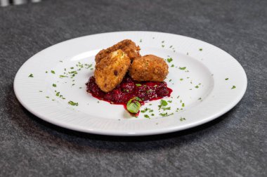 Beyaz tabakta tatlı kızılcık soslu kızarmış Camembert peyniri. Gurme Aperatif Yemekler ve Tatil Menüleri İçin Mükemmel