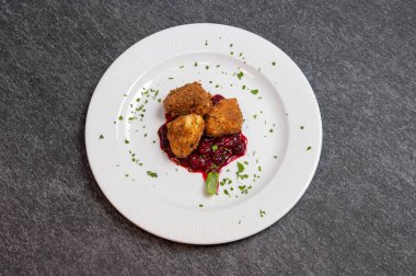 Beyaz tabakta tatlı kızılcık soslu kızarmış Camembert peyniri. Gurme Aperatif Yemekler ve Tatil Menüleri İçin Mükemmel