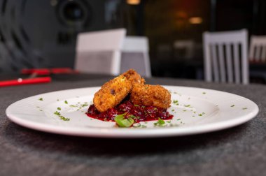 Beyaz tabakta tatlı kızılcık soslu kızarmış Camembert peyniri. Gurme Aperatif Yemekler ve Tatil Menüleri İçin Mükemmel