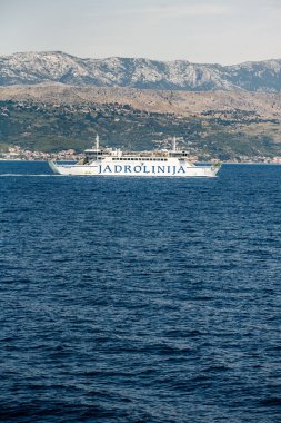 Ayrıl, Hırvatistan. 16 Temmuz 2019: Jadrolinija feribotu Marjan, arka planda Dalmaçya kıyı şeridi ve Mosor dağlarıyla Adriyatik Denizi 'ne yelken açıyor