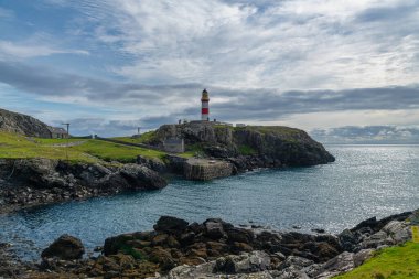Minch 'ten Skye Adası' na bakan kırmızı-beyaz Eilean Glas Deniz Feneri Outer Hebrides, İskoçya, İngiltere 'deki Scalpay adasının doğu kıyısında.
