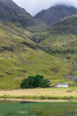 Glencoe, İskoçya 'da fırtınalı, gri gökyüzü olan muhteşem bir dağ manzarası.