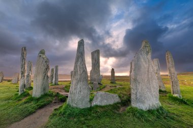 Callanish 'in (veya Calanais) İskoçya' nın dışındaki Hebrides 'te gün batımında Lewis üzerinde bulunan antik ayakta duran taşları.