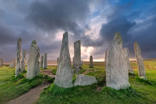 Callanish 'in (veya Calanais) İskoçya' nın dışındaki Hebrides 'te gün batımında Lewis üzerinde bulunan antik ayakta duran taşları.