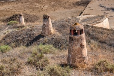 Mağara çöplüğünde bacaları olan ünlü mağara evleri, Barrio de las Cuevas mağara bölgesi, Guadix, İspanya