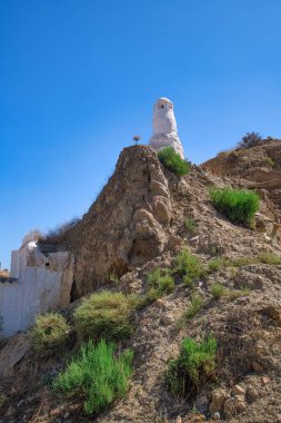 Mağara çöplüğünde bacaları olan ünlü mağara evleri, Barrio de las Cuevas mağara bölgesi, Guadix, İspanya