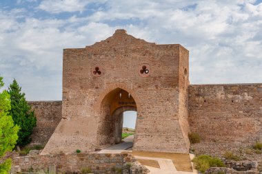 Sagunt 'taki kale manzarası, kalın duvarlar, büyük bir kapı, kısmen harap olmuş binalar ve temeller.