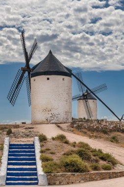 Consuegra, Toledo bölgesindeki Knolls 'da rüzgar değirmenleri, Castilla La Mancha, İspanya. Don Kişot 'un yel değirmenli yolu. Mavi gökyüzü ve bulutlu yaz manzarası