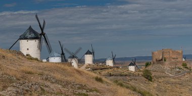 Consuegra, Toledo bölgesindeki Knolls 'da rüzgar değirmenleri, Castilla La Mancha, İspanya. Don Kişot 'un yel değirmenli yolu. Mavi gökyüzü ve bulutlu yaz manzarası